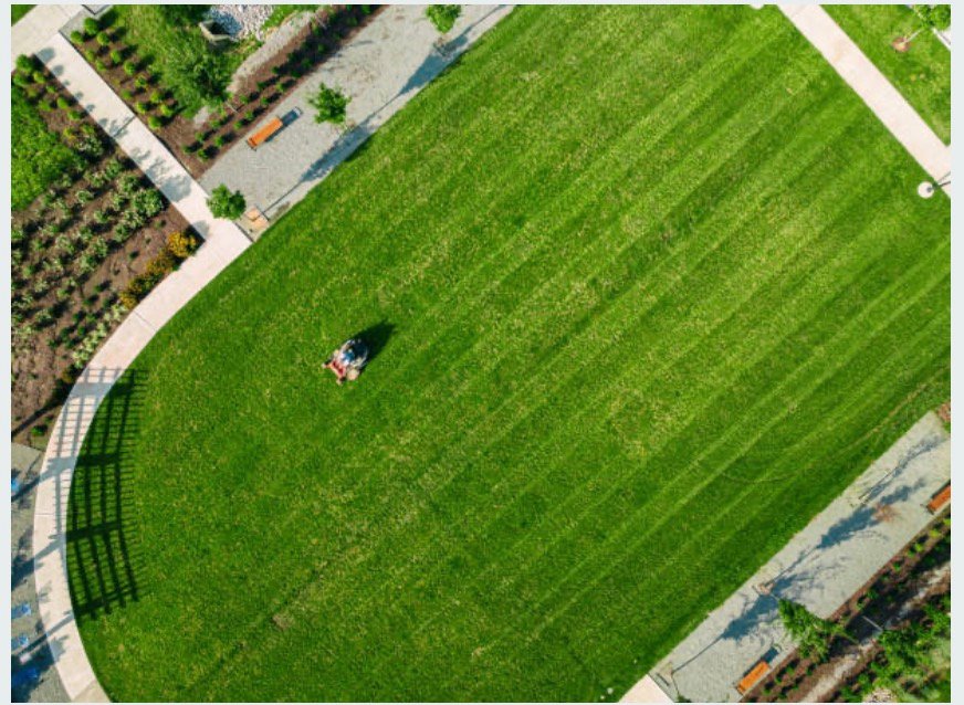 Aerial view of the Evergreen crew mowing crisp lines across an open lawn